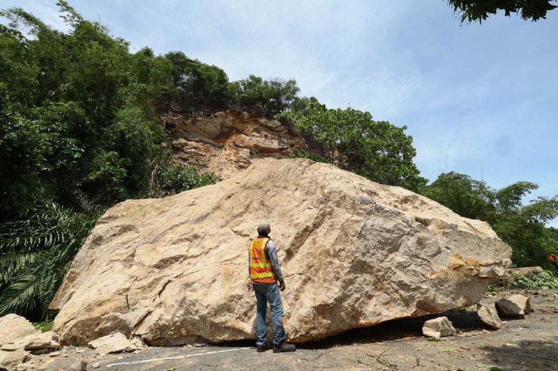 巨石突从山坡滚落 直砸沙巴州一条公路堪比两人高度的巨石突然从沙巴州山打根一处山坡滚落，径直砸在马路上，所幸事发时没人经过，没有造成人员伤亡